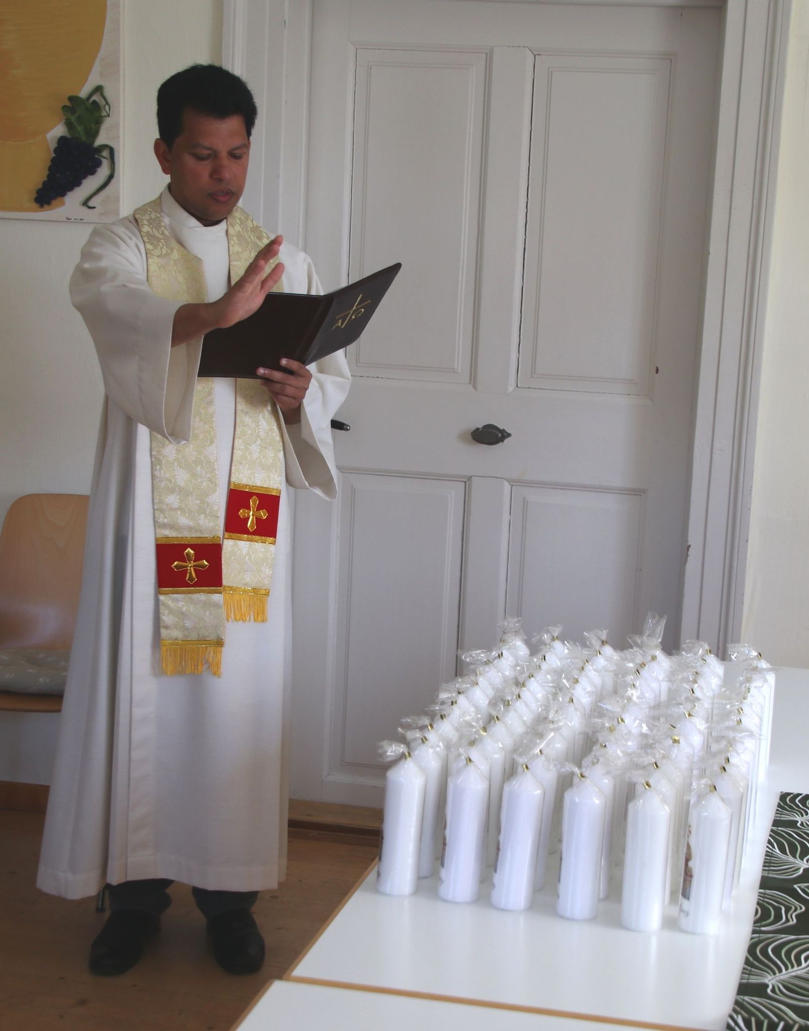 Pater Silvester segnet Kerzen